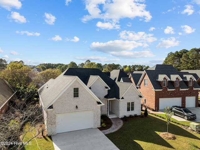 view of front of house with driveway, brick siding, and a front yard