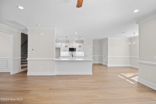 unfurnished living room with light wood finished floors, stairway, a chandelier, and crown molding