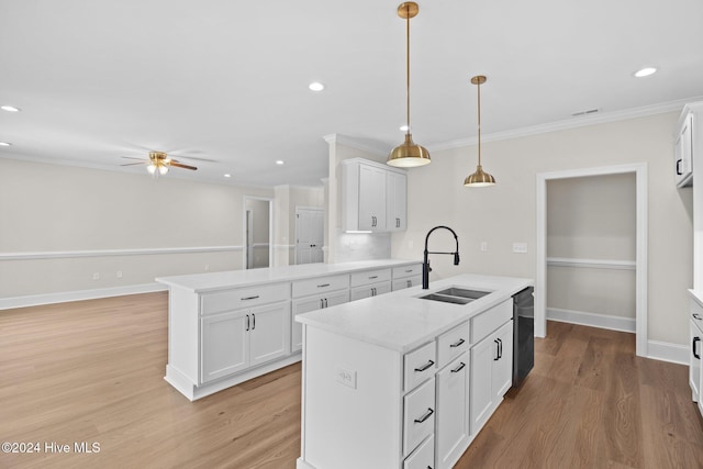 kitchen featuring black dishwasher, ornamental molding, light wood-type flooring, and a sink