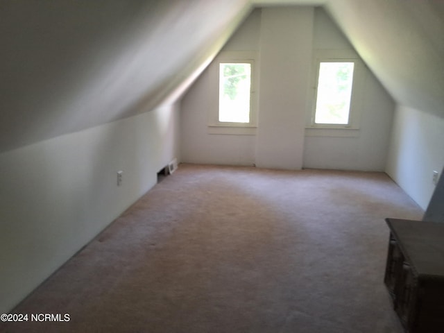 bonus room featuring light colored carpet and vaulted ceiling