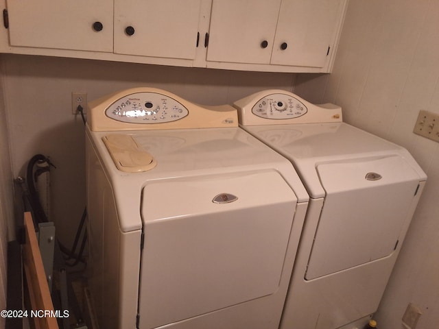 clothes washing area featuring cabinets and separate washer and dryer