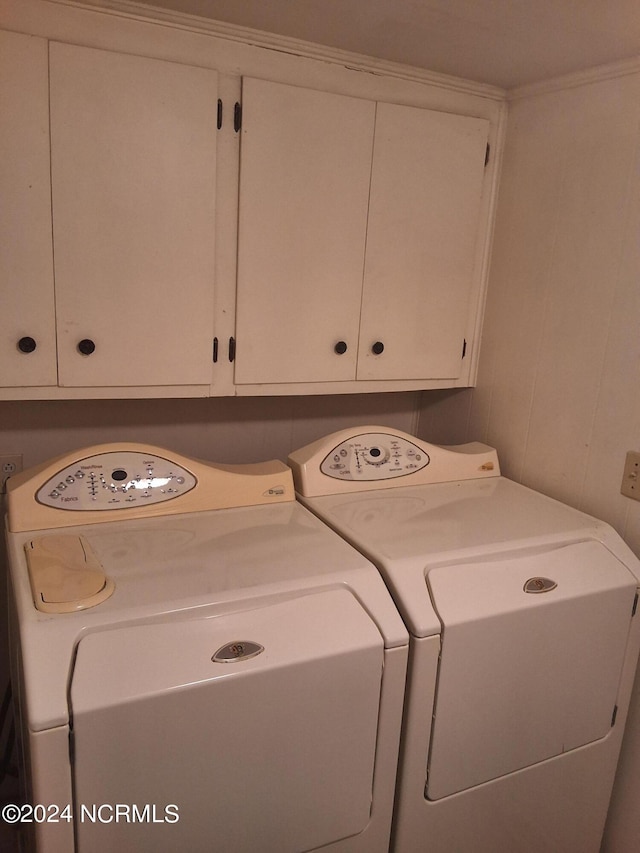 laundry room featuring washer and dryer and cabinets