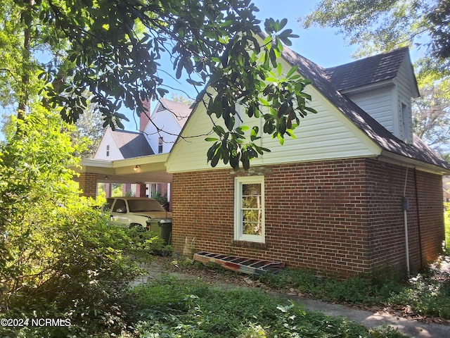 view of side of home with a carport