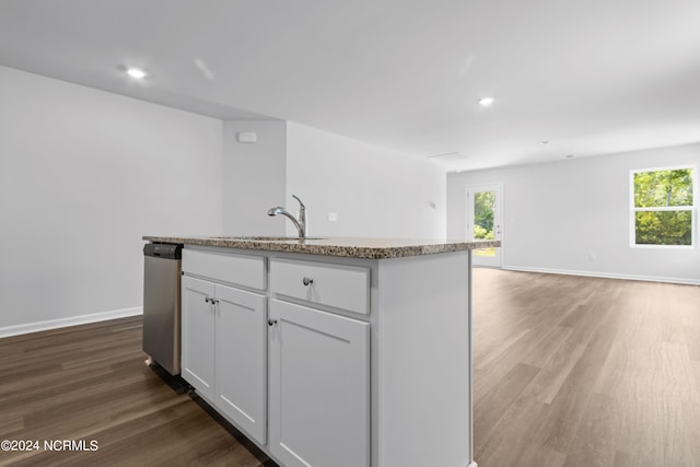 kitchen featuring a center island with sink, sink, stainless steel dishwasher, dark hardwood / wood-style flooring, and white cabinetry