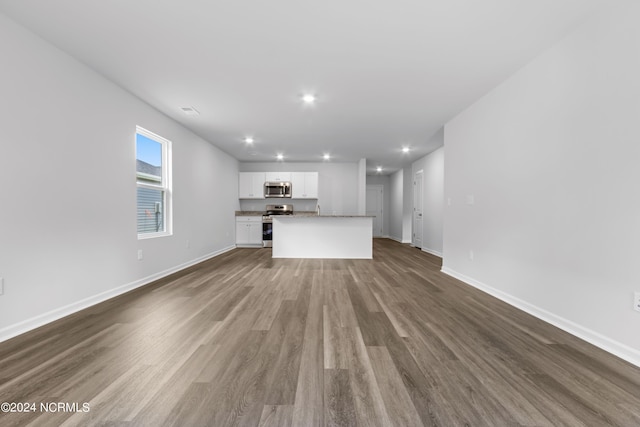 unfurnished living room with dark wood-type flooring