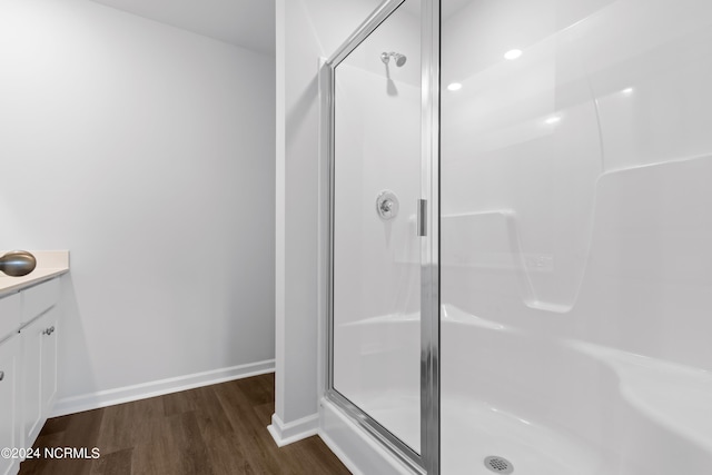 bathroom featuring hardwood / wood-style floors, vanity, and walk in shower