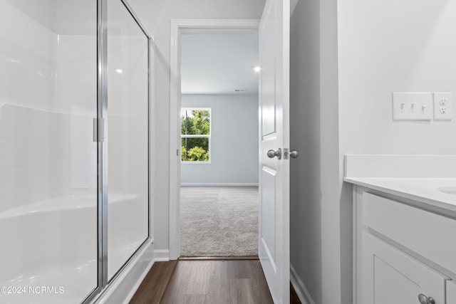 bathroom featuring a shower with door, vanity, and hardwood / wood-style flooring