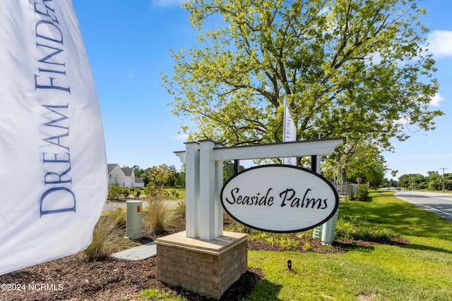 community sign featuring a lawn