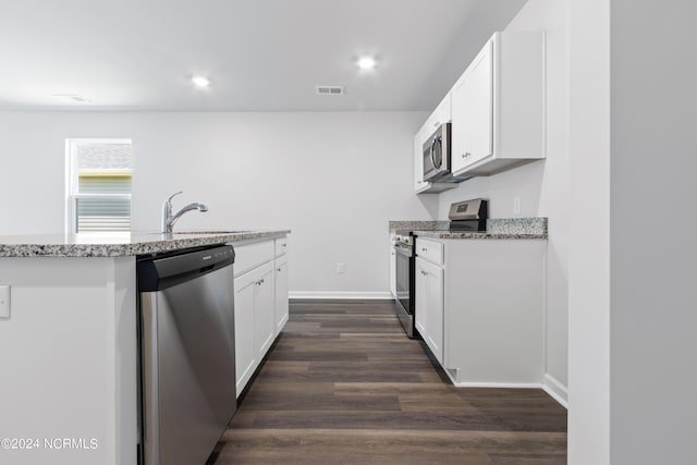 kitchen with light stone countertops, stainless steel appliances, white cabinetry, and sink