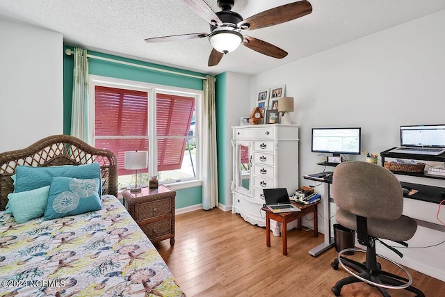 bedroom featuring a textured ceiling, ceiling fan, wood finished floors, and baseboards