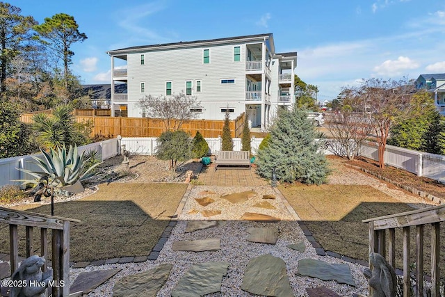 back of house featuring a fenced backyard and a lawn