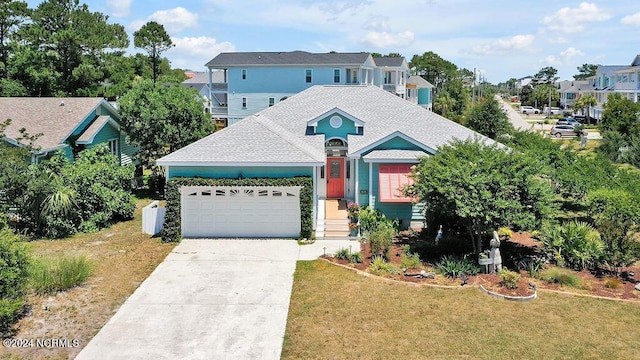 view of front of property featuring driveway, a shingled roof, a residential view, an attached garage, and a front yard