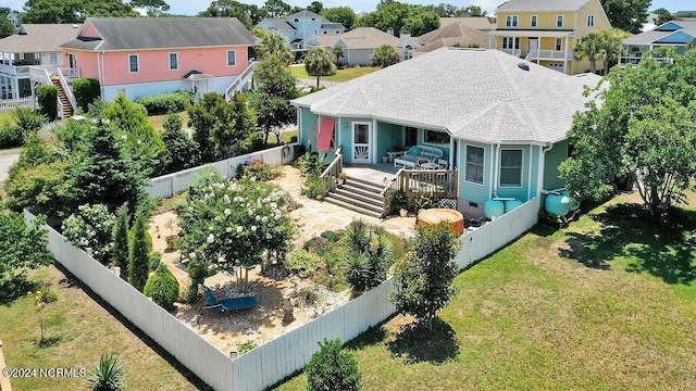 view of front of home featuring a wooden deck, a front lawn, a fenced backyard, and a residential view