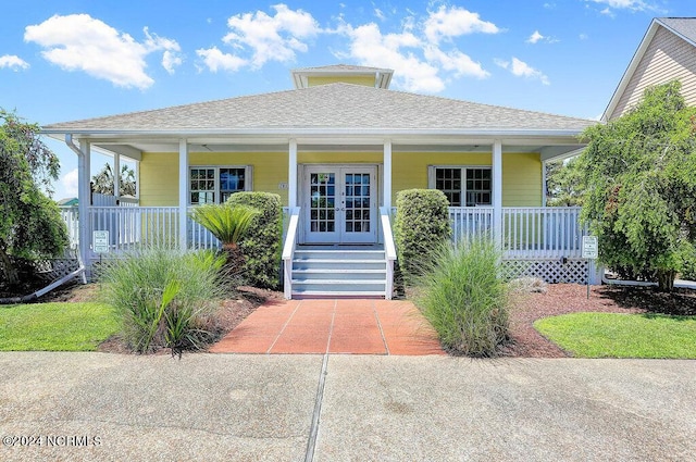 view of front of house with french doors, roof with shingles, and a porch