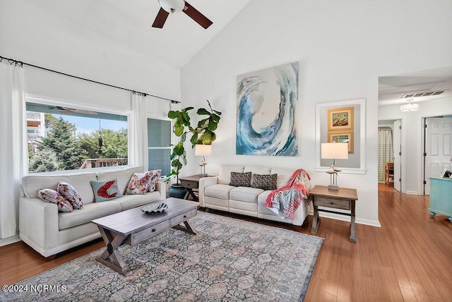 living area with visible vents, ceiling fan, wood finished floors, high vaulted ceiling, and baseboards