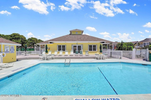 community pool featuring fence and a patio