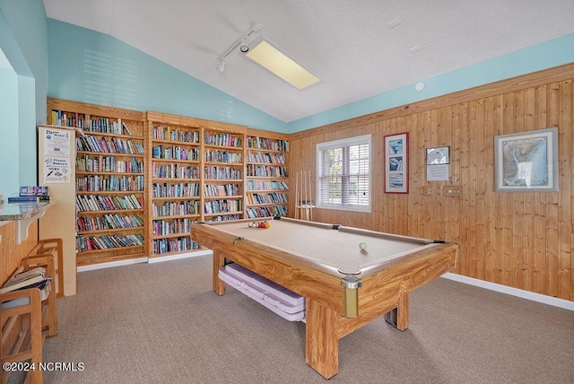 rec room with rail lighting, carpet flooring, vaulted ceiling, and wooden walls