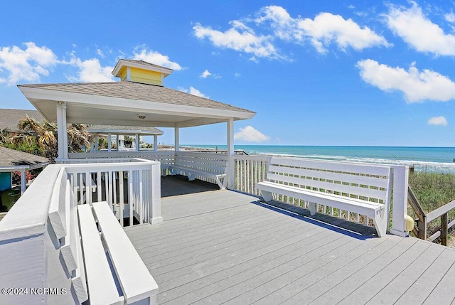 dock area with a view of the beach, a water view, and a gazebo