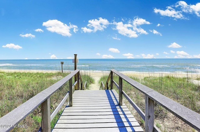 view of property's community with a water view and a view of the beach