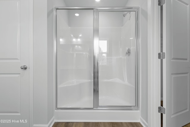 bathroom with hardwood / wood-style flooring and walk in shower