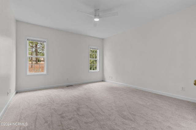 carpeted empty room with ceiling fan and a healthy amount of sunlight