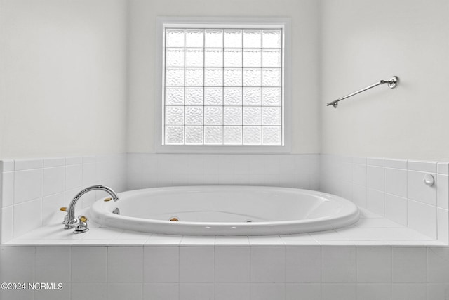 bathroom with a relaxing tiled tub