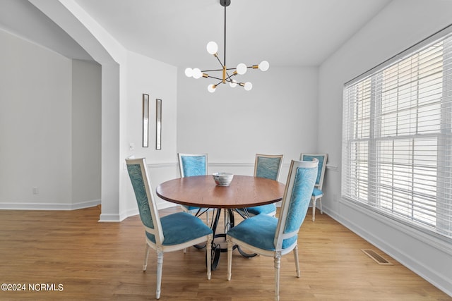 dining area featuring an inviting chandelier and light hardwood / wood-style floors