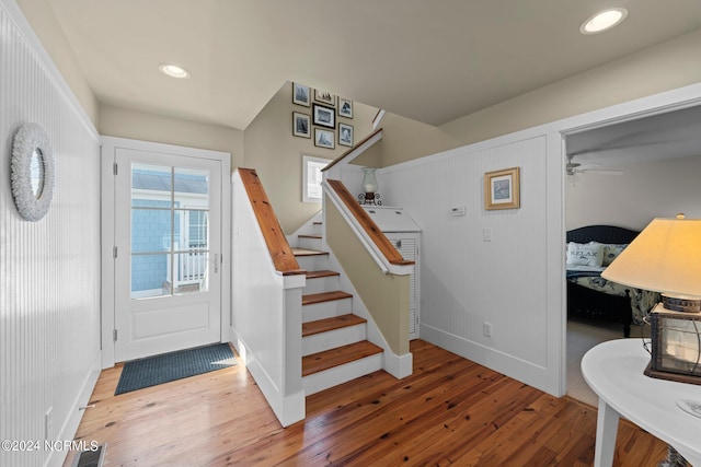 staircase with hardwood / wood-style flooring and ceiling fan