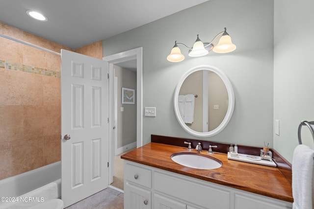 bathroom with tile patterned floors, vanity, and tiled shower / bath combo