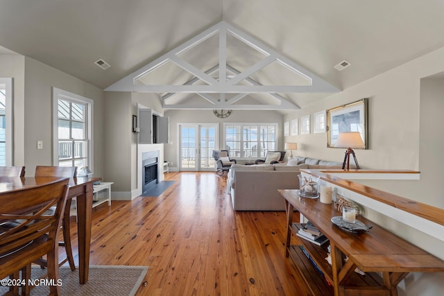 living room with light wood-type flooring and vaulted ceiling