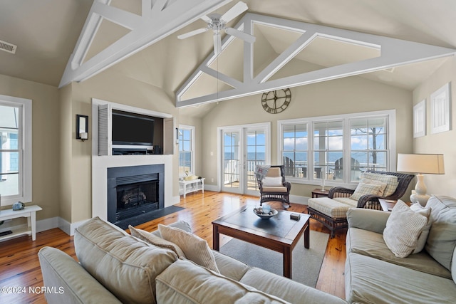 living room with wood-type flooring, vaulted ceiling, and ceiling fan