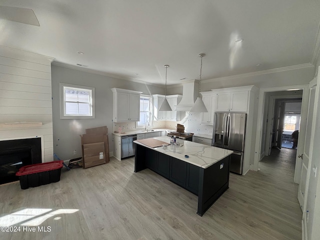 kitchen with white cabinetry, a center island, stainless steel appliances, pendant lighting, and custom range hood