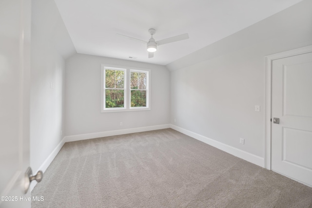 carpeted empty room with vaulted ceiling and ceiling fan