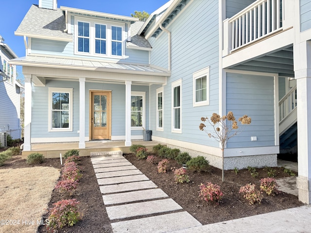 doorway to property with central AC unit and covered porch