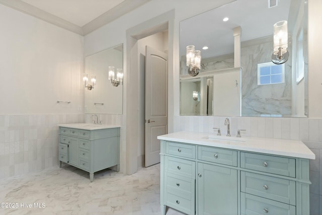 full bathroom featuring marble finish floor, two vanities, a sink, and tile walls