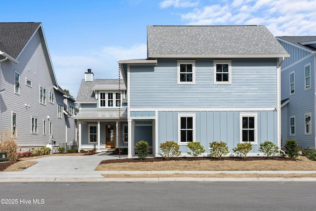 view of front of property with metal roof, a porch, a shingled roof, board and batten siding, and a chimney