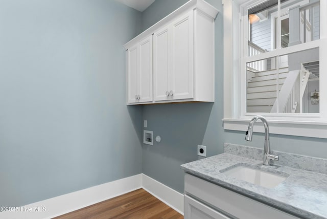 laundry area with hookup for a washing machine, cabinet space, a sink, electric dryer hookup, and baseboards