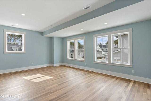 empty room featuring visible vents, baseboards, wood finished floors, and recessed lighting