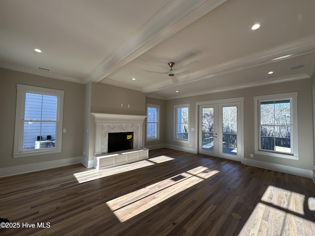 unfurnished living room with dark hardwood / wood-style floors, a high end fireplace, crown molding, beam ceiling, and french doors