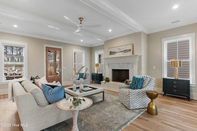 living room with recessed lighting, wood finished floors, visible vents, a high end fireplace, and beamed ceiling