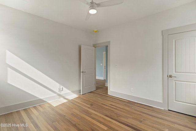 empty room featuring ceiling fan, wood finished floors, and baseboards