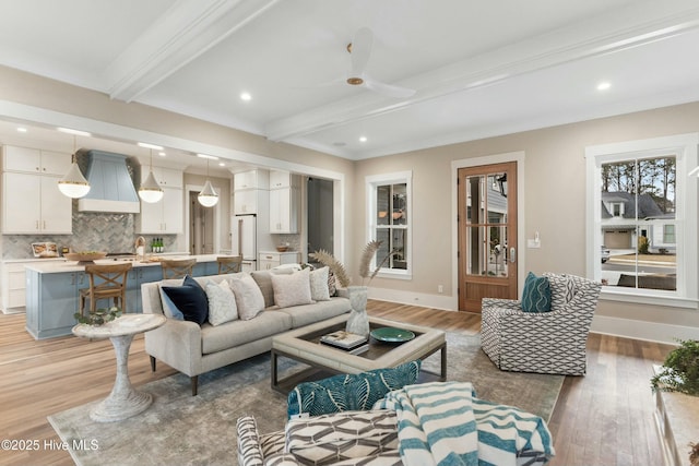 living room featuring light wood-style flooring, baseboards, and beamed ceiling