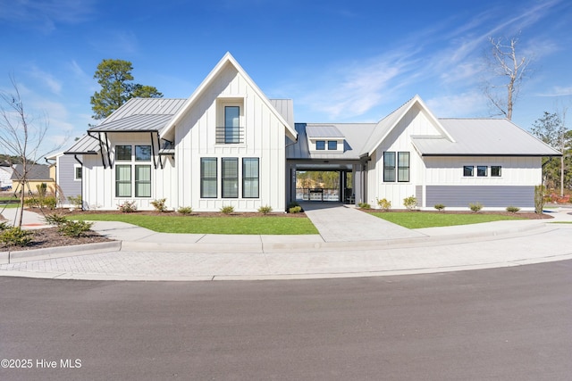 modern farmhouse with a standing seam roof, an attached carport, and board and batten siding