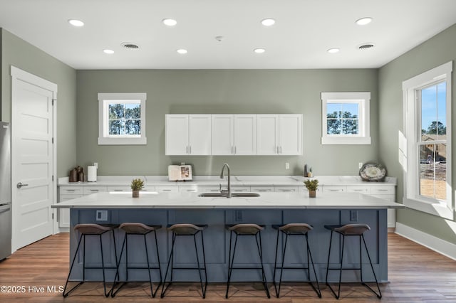 kitchen with a healthy amount of sunlight, visible vents, a sink, and white cabinetry