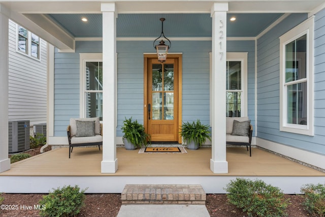 doorway to property featuring covered porch and central AC