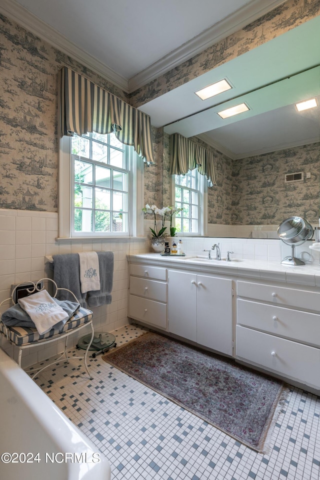 bathroom featuring tile patterned floors, crown molding, vanity, and tile walls