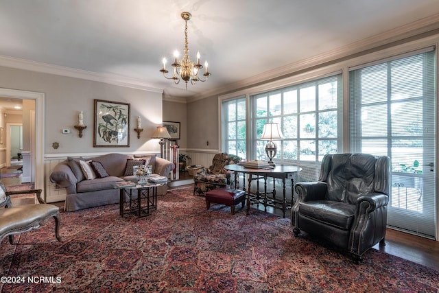 living room featuring wood-type flooring, an inviting chandelier, and ornamental molding