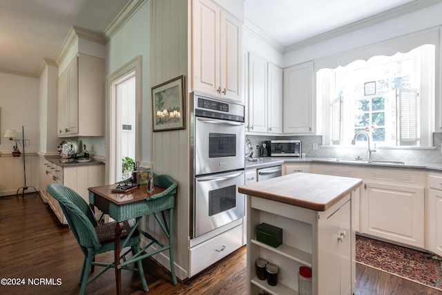 kitchen with dark hardwood / wood-style flooring, double oven, sink, a center island, and white cabinetry