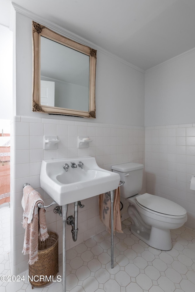 bathroom featuring tile patterned floors, crown molding, sink, tile walls, and toilet