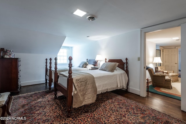 bedroom with dark hardwood / wood-style flooring and vaulted ceiling